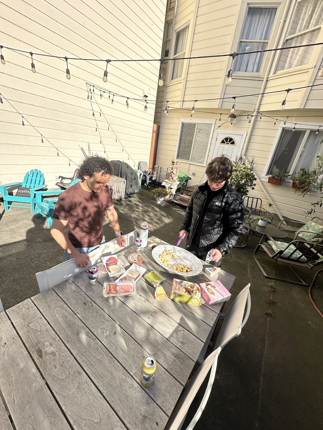 Two residents preparing food at the backyard table