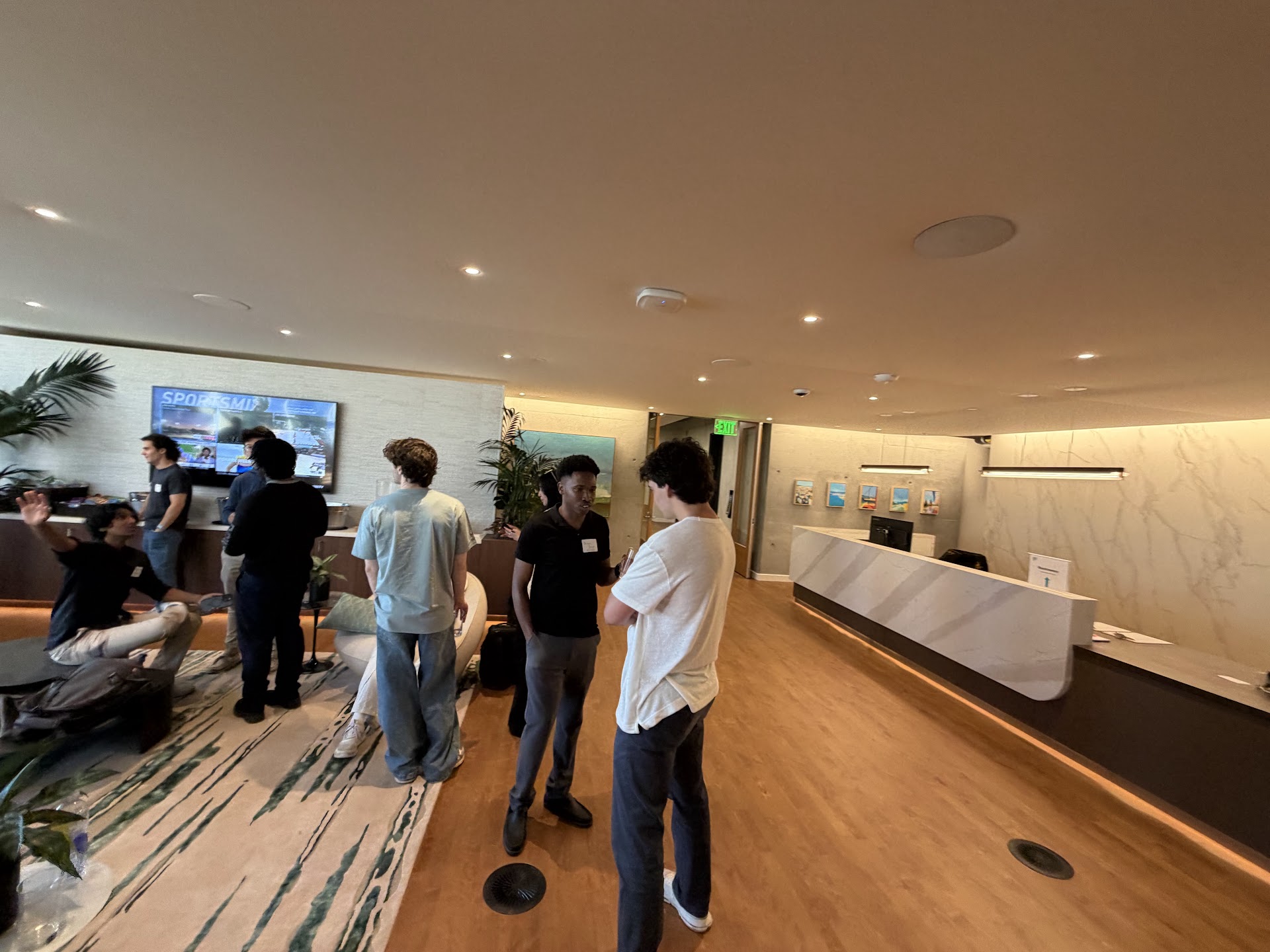 Residents and guests talking in small groups at Demo Day