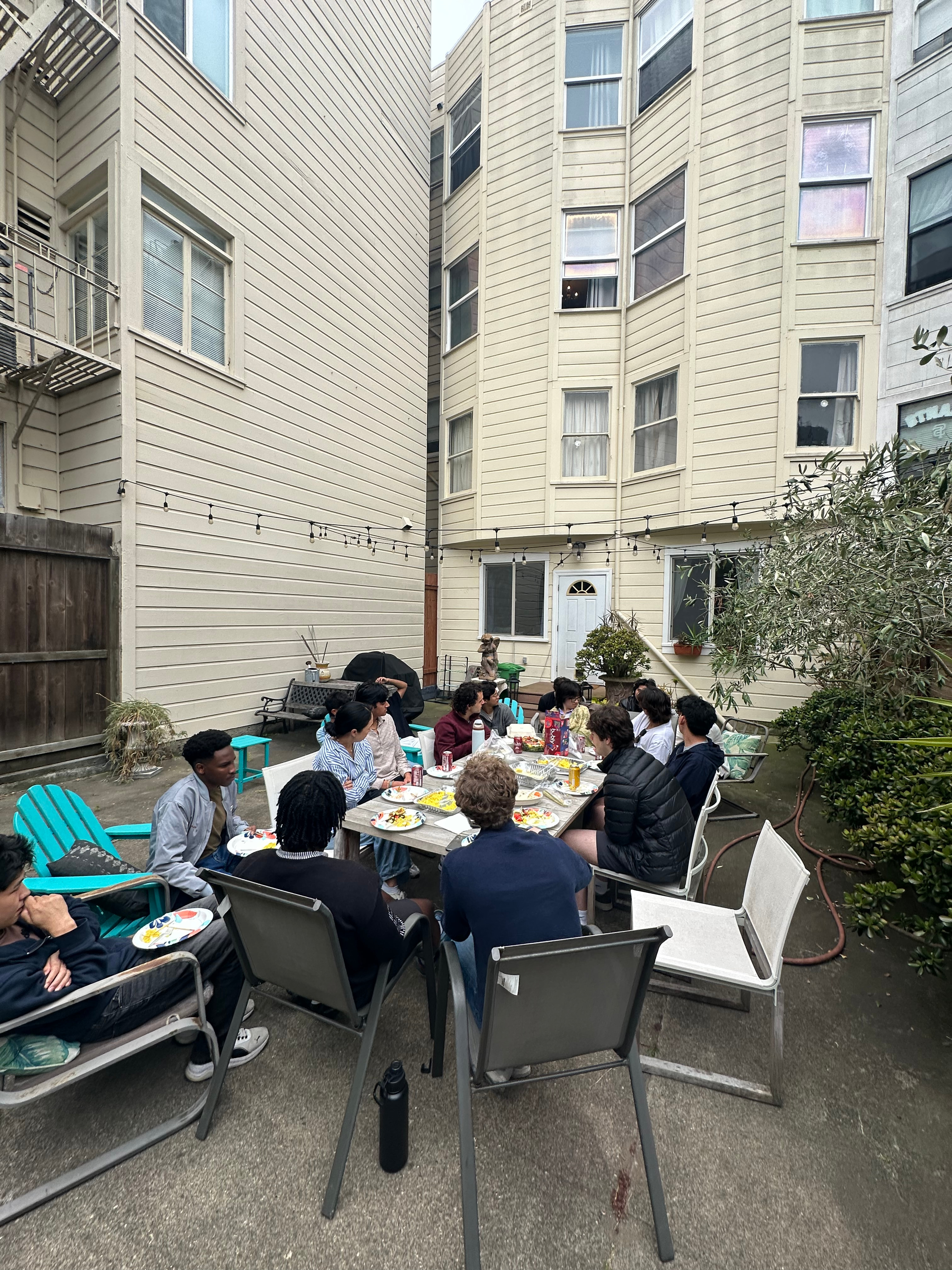 Ann Miura-Ko talking with residents around the backyard table