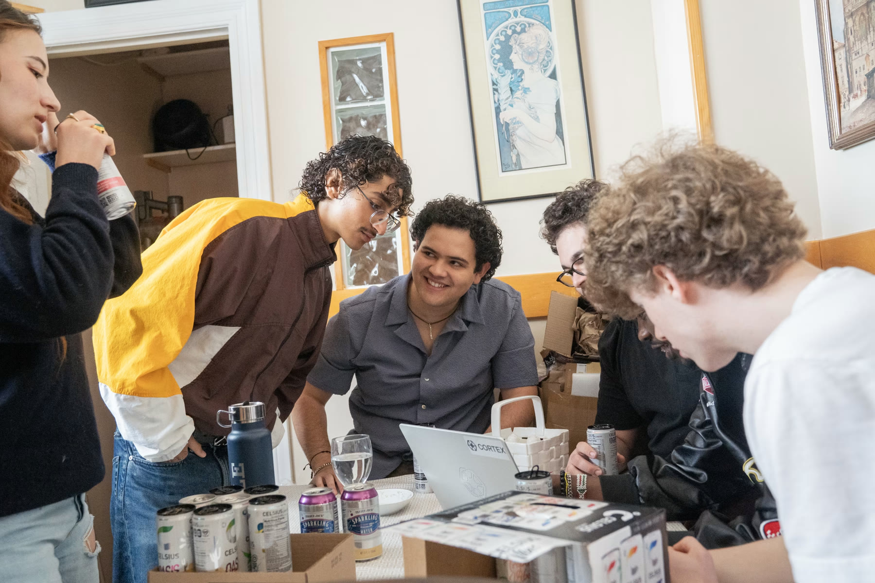 Residents leaning together around a laptop at the shared table